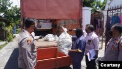 Petugas polisi dari Kepolisian Resort Sukoharjo menunjukkan kantong-kantong yang digunakan untuk menyimpan 53 anjing yang akan dikirim ke pedagang kuliner daging anjing di Jawa Tengah, pada 25 November 2021. (Foto: Courtesy Polres Sukoharjo)