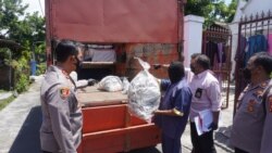 Petugas polisi dari Kepolisian Resort Sukoharjo menunjukkan kantong-kantong yang digunakan untuk menyimpan 53 anjing yang akan dikirim ke pedagang kuliner daging anjing di Jawa Tengah, pada 25 November 2021. (Foto: Courtesy Polres Sukoharjo)