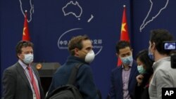 Koresponden New York Times di Beijing, Steven Lee Myers (kiri), berbincang dengan wartawan asing lainnya setelah menghadiri pertemuan harian dengan pers di kantor Kemenlu China di Beijing, Rabu, 18 Maret 2020. 