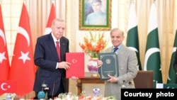 Turkish President Recep Tayyip Erdogan, left, and Pakistani Prime Minister Shahbaz Sharif hold copies of a joint declaration at the Pakistan-Turkey High Level Strategic Cooperation Council in Islamabad, Feb. 13, 2025. (Ministry of Information and Broadcasting, Pakistan)