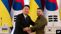 韩国总统尹锡悦在基辅与乌克兰总统泽连斯基握手。（2023年7月15日）