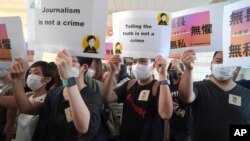 FILE - Supporters of Hong Kong journalist Bao Choy, fined for accessing a public database for an investigative report, hold placards outside a court in Hong Kong, April 22, 2021. 
