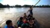 FILE - Central American migrants cross into Mexico from Guatemala, near Ciudad Hidalgo, Mexico, June 4, 2019. The migrants walked over the bridge and waited to register at a Mexican immigration office.