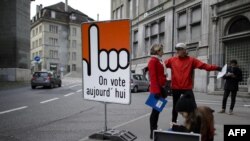 瑞士街头有标语牌，写着“我们今天投票”