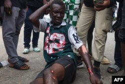 A protester lies looks at his injuries following clashes with Nigerian security forces during the End Bad Governance protest in Abuja, Aug. 2, 2024.