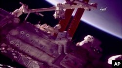 美国宇航员马克·范德·海伊与斯科特·庭格尔在国际空间站外为一个机器人按照新手臂。（2018年1月23日）