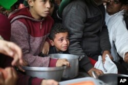 Warga Palestina mengantre untuk mendapatkan distribusi makanan gratis selama serangan udara dan darat Israel yang sedang berlangsung di Khan Younis, Jalur Gaza, Jumat, 2 Februari 2024. (Foto: AP/Hatem Ali)