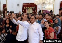 Presiden Joko Widodo dan Prabowo Subianto berswafoto bersama para wartawan di istana kepresidenan, 11 Oktober 2019. (Foto: presidenri.go.id)