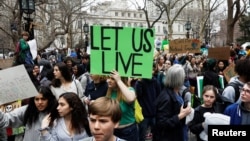 Para siswa mengacungkan poster-poster dalam unjuk rasa perubahan iklim di New York, 15 Maret 2019. 