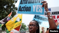 资料照片:美国首都华盛顿,一名妇女举着标语,支持和反对美国最高法院驳回哈佛大学和北卡罗来纳大学考虑种族因素的学生录取计划的示威者在对峙。(2023年6月29日)