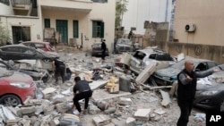 People search through the rubble of a destroyed building at the site of an Israeli airstrike in central Beirut's Ras el-Nabaa neighborhood, Lebanon, Nov. 17, 2024.
