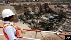 កម្មករ​សំណង់​ម្នាក់​កំពុង​ពិនិត្យ​មើល​​ដំណើរការ​ការ​ស្ថាបនា​រោងចក្រ​ថាមពល​នៅ​សំណង់​ទំនប់​វារី​អគ្គិសនី​​ ណាំធឿន២ (Nam Theun 2) នៅ​ភាគ​អាគ្នេយ៍​​នៃ​រដ្ឋធានី​វៀងចន្ទន៍​​របស់​ប្រទេស​ឡាវ កាល​ពី​ថ្ងៃ​ទី​៦​ខែ​សីហា​ឆ្នាំ​២០០៦។