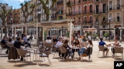 Ljudi sede u bašti kafića u Taragoni, u Španiji (Foto: AP)
