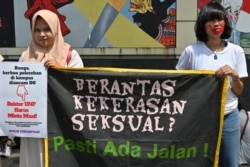 Aktivis perempuan dari gerakan antikekerasan memegang spanduk bertuliskan "Memberantas Kekerasan Seksual? Pasti Ada Jalan!" saat protes pelecehan seksual dan kekerasan terhadap perempuan. (Foto: AFP/Adek Berry)
