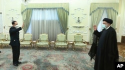 Presiden Iran Ebrahim Raisi (kanan) dan Menteri Pertahanan Nasional China Wei Fenghe saling menyapa dalam pertemuan di kantor kepresidenan Iran di Teheran, pada 27 April 2022. (Foto: Iranian Presidency Office via AP)