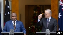 Perdana Menteri Australia Anthony Albanese (kanan) bersama dengan Perdana Menteri Papua Nugini James Marape hadir dalam konferensi pers di gedung parlemen di Canberra pada 7 Desember 2023. (Foto: AFP/Hilary Wardhaugh)