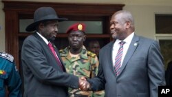 FILE - South Sudanese President Salva Kiir, left, and Vice President Riek Machar shake hands after meetings in Juba, South Sudan, on Oct. 20, 2019, to discuss outstanding issues to a peace deal.