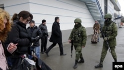 Ukraine -- Armed men patrol near a building of the airport in Simferopol, Crimea, February 28, 2014. Ukraine accused Russia of sending thousands of extra troops to Crimea.