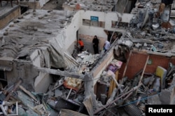 Warga Palestina memeriksa kerusakan di lokasi serangan Israel terhadap rumah-rumah, di tengah konflik yang sedang berlangsung antara Israel dan kelompok Islam Palestina Hamas, di Khan Younis di selatan Jalur Gaza, 29 Oktober 2023. (Foto: REUTERS/Mohammed Salem)