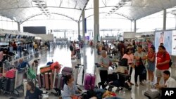 Travelers wait to check in for their flights at the airport in Hong Kong, Aug. 14, 2019. Flights resumed at Hong Kong's airport Wednesday morning. 