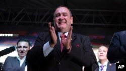 Alejandro Giammatei, kandidat presiden partai Vamos, bertepuk tangan di hadapan para pendukungnya setelah pengumuman hasil pemilu di Guatemala City, 11 Agustus 2019.