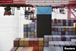 FILE - Containers are seen unloaded from the Maersk's Triple-E giant container ship Maersk Majestic, one of the world's largest container ships, at the Yangshan Deep Water Port, part of the Shanghai Free Trade Zone, in Shanghai, China, Sept. 24, 2016.