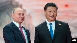Presiden China Xi Jinping, kanan, dan Presiden Rusia Vladimir Putin di KTT Organisasi Kerjasama Shanghai (SCO) Summit di Qingdao, China, 10 Juni 2018.