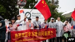FILE - Supporters gather on a road during a visit by China's Premier Li Qiang to the New Zealand Institute for Plant and Food Research at Mt Albert in Auckland on June 14, 2024. 