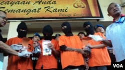Empat orang berbaju tahanan warna oranye dikawal sejumlah petugas polisi bersenjata lengkap di Polresta Solo, Rabu siang, 1 Juni 2016 (Foto: VOA/Yudha).