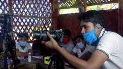 Seorang instruktur memberikan pelatihan fotografi di kamp pengungsi Rohingya di Bangladesh (foto: Reuters).
