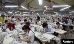 FILE - Laborers work at a garment factory in Bac Giang province, near Hanoi, Oct. 21, 2015.