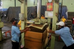 Pekerja mengepak tembakau yang akan dikirim ke beberapa industri besar rokok di Indonesia. (Foto: VOA/Petrus Riski).