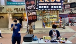 Michael(左)认同家长为了子女有更好学习及成长环境带同子女移民，不需要被国安法“维稳教材”洗脑。（美国之音 / 汤惠芸）