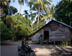 អ្នក​ភូមិ​ម្នាក់​ជិះ​ម៉ូតូ​នៅ​ក្បែរ​ផ្ទះ​របស់​លោក ដែល​ស្ថិត​ក្នុង​តំបន់​ជួរ​ភ្នំ​ក្រវាញ។ តំបន់​ព្រៃ​អភិរក្ស​ជា​ច្រើន​នៅក្នុង​ប្រទេស​កម្ពុជា មានតែ​នៅ​ក្នុង​ផែនទី​និង​ឯកសារ​ច្បាប់​តែ​ប៉ុណ្ណោះ ប៉ុន្តែ​ទទួល​បាន​ការ​ការពារ​ជាក់ស្ដែង​តិចតួច ដែល​ធ្វើ​ឲ្យ​តំបន់​ទាំង​នោះ​ងាយ​នឹង​រង​ការ​ទន្ទ្រាន​ខុស​ច្បាប់​ពី​គម្រោង​អភិវឌ្ឍន៍​ឧស្សាហកម្ម​និង​កសិកម្ម​នានា។