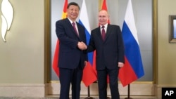 Presiden Rusia Vladimir Putin (kanan) dan Presiden China Xi Jinping bertemu di Astana, Kazakhstan hari Rabu (3/7). 