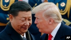 FILE - U.S. President Donald Trump, right, chats with Chinese President Xi Jinping in Beijing, China.