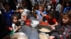 FILE - Displaced Palestinian children line up to receive food in Rafah, on the southern Gaza Strip on April 19, 2024, amid ongoing battles between Israel and Hamas. 