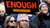 FILE - A woman holds a sign expressing her opinion about impeaching President Donald Trump at a rally organized by Women's March NYC at Foley Square in Lower Manhattan in New York, , Jan. 19, 2019. 