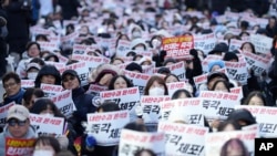 Participants shout slogans during a rally calling on the Constitutional Court to dismiss the President Yoon Suk Yeol in Seoul, Dec. 15, 2024. The signs read "Immediately arrest."