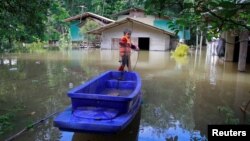 FILE - A boy catches fish in an area affected by floods in Yala province, southern Thailand, Jan. 21, 2017. Flooding in the northern and eastern regions have killed at least 23 people.