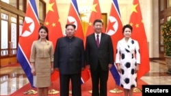 中国国家主席习近平和夫人彭丽媛在北京人大会堂同朝鲜国务委员会委员长金正恩和夫人李雪主合影。（2018年3月28日）