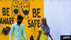 Dinding bergambar pesan layanan masyarakat tentang kesadaran pandemi corona di Mumbai, 23 Maret 2020. (Foto: dok). 