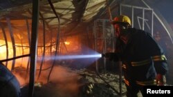 Nhân viên cứu hỏa Bangladesh kiểm tra hiện trường sau vụ hỏa hoạn bên trong nhà máy dệt may Gazipur, ngày 9/10/2013.