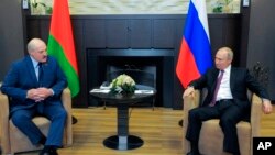Presiden Rusia Vladimi Putin (kanan) dan Presiden Belarus Alexander Lukashenko berbincang-bincang saat pertemuan di resor Laut Hitam, Sochi, di Rusia, Jumat, 28 Mei 2021. (Foto: Mikhail Klimentyev, Sputnik, Kremlin Pool Photo via AP)