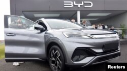 资料照片: 2023年4月28日英国法恩伯勒举行的电动汽车贸易展上，媒体和公众在观看中国汽车制造商比亚迪生产的Atto 3电动运动休旅车