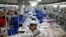 FILE - North Korean employees, shown in December 2013, sew in a South Korean-owned company at the Kaesong industrial park just north of the demilitarized zone. 