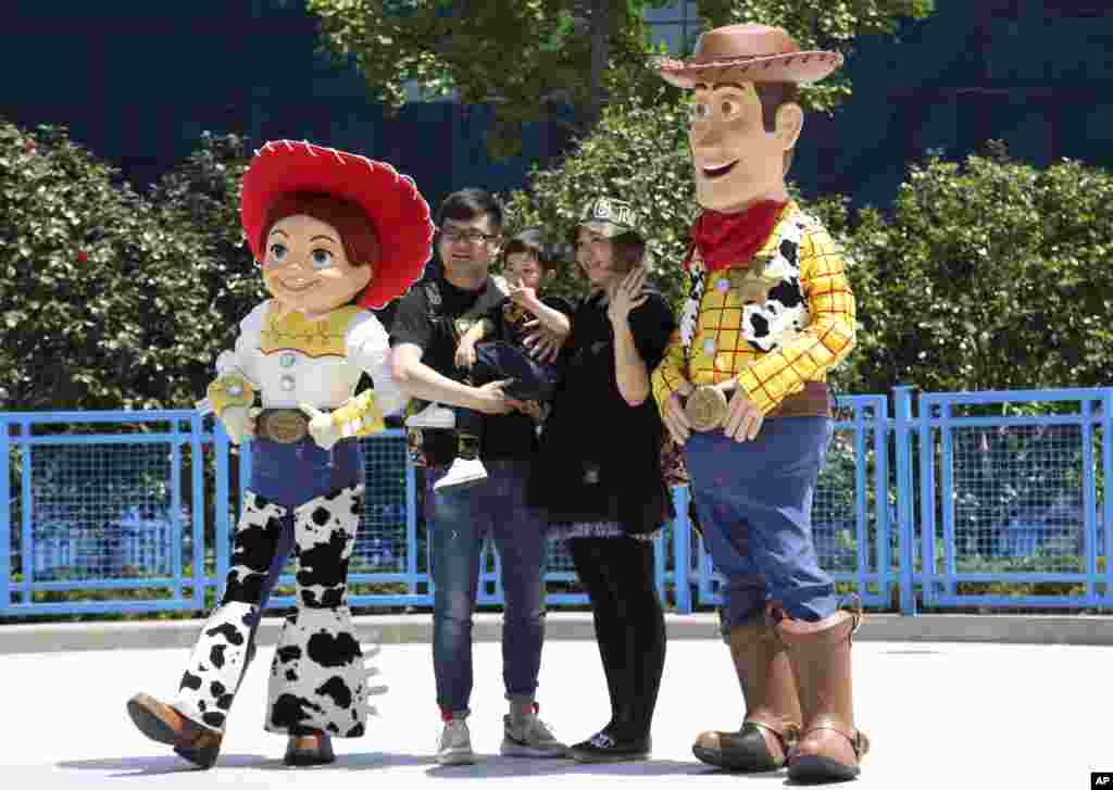 2018年4月26日,上海迪士尼乐园的玩具总动员园区开幕时,一家人和“玩具总动员”电影角色合影。这个园区耗资55亿美元。在美中贸易关系紧张之际,华特迪士尼公司强调其与中国的深层关系