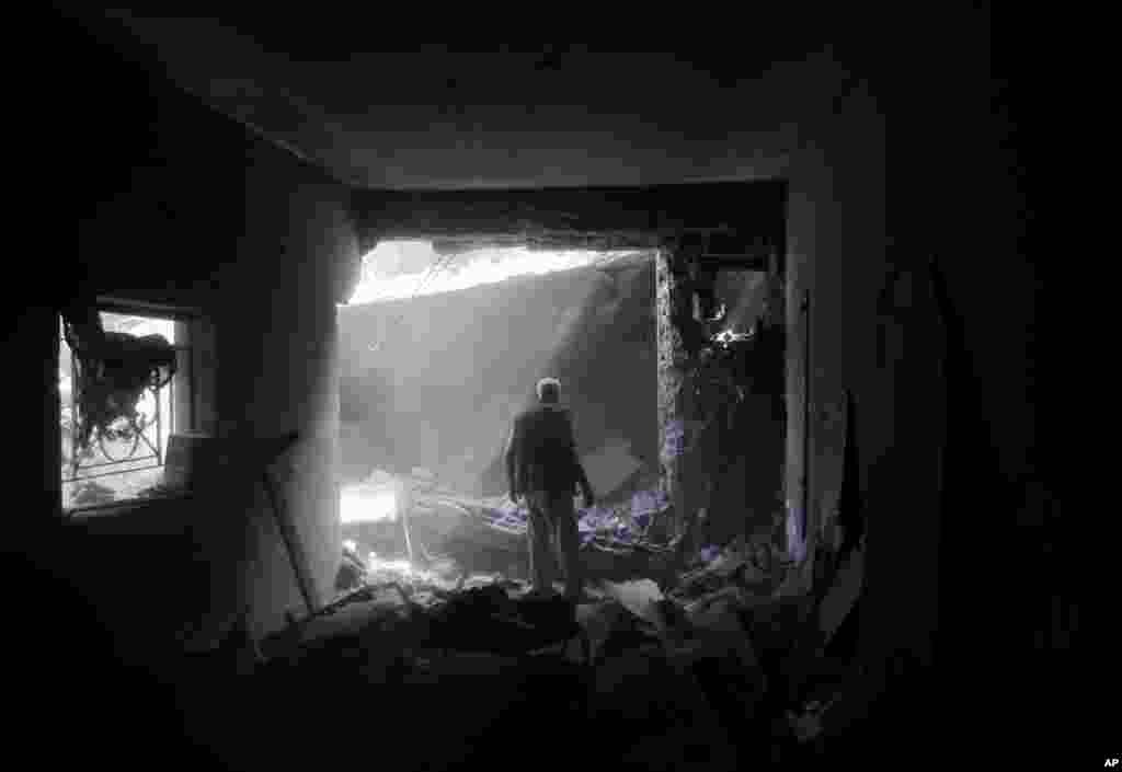 A member of the Shabat family inspects damage upon returning to the family house, destroyed by Israeli strikes in the town of Beit Hanoun, northern Gaza Strip, Aug. 5, 2014.
