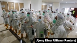 Petugas kesehatan yang mengenakan alat pelindung diri (APD) bersiap untuk merawat pasien di rumah sakit darurat COVID-19 di Wisma Atlet, Jakarta, 26 Januari 2021. (REUTERS/Ajeng Dinar Ulfiana)