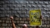 FILE - A protester holds a Black Lives Matter sign outside the U.S. consulate during a demonstration against racism and police brutality in Hong Kong, June 7, 2020.